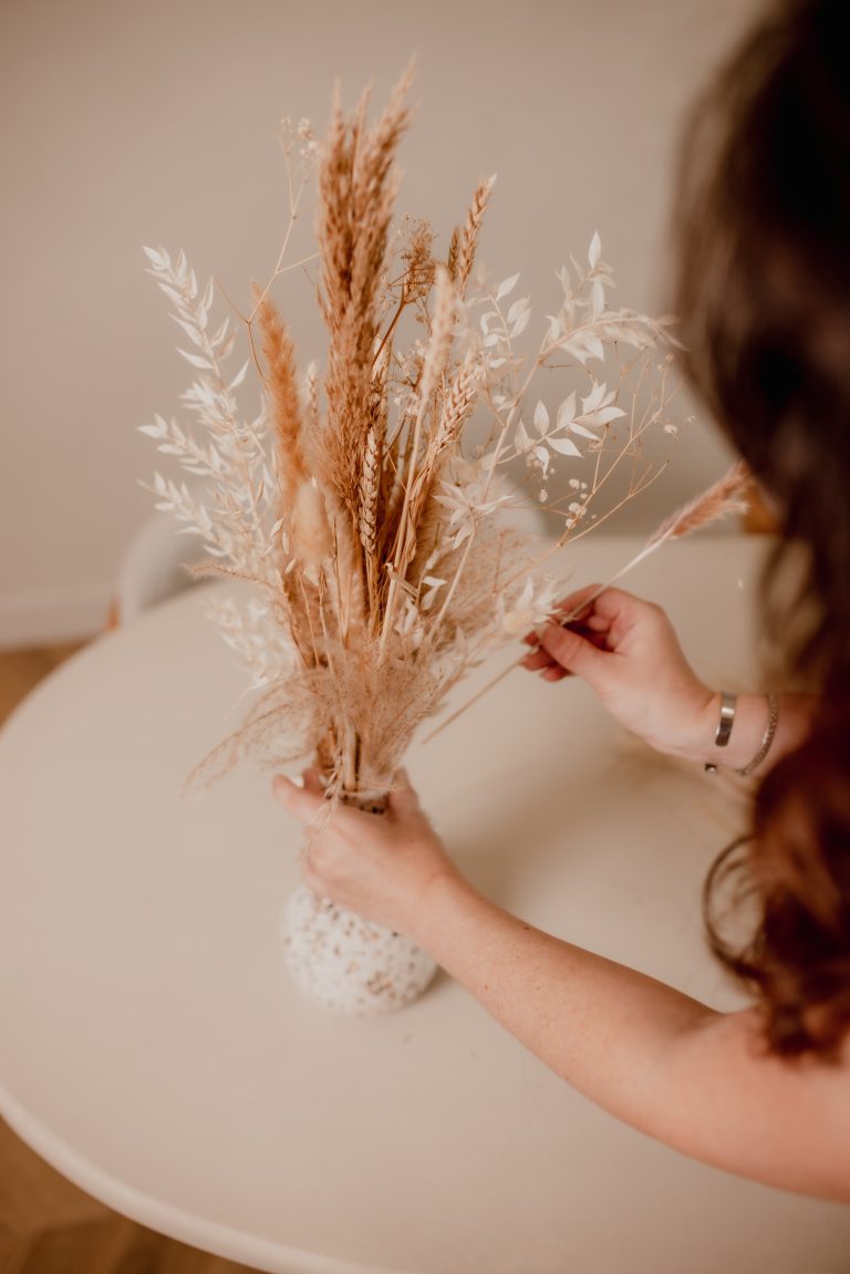Eelke schikt droogbloemen in een vaas tijdens de brandingshoot